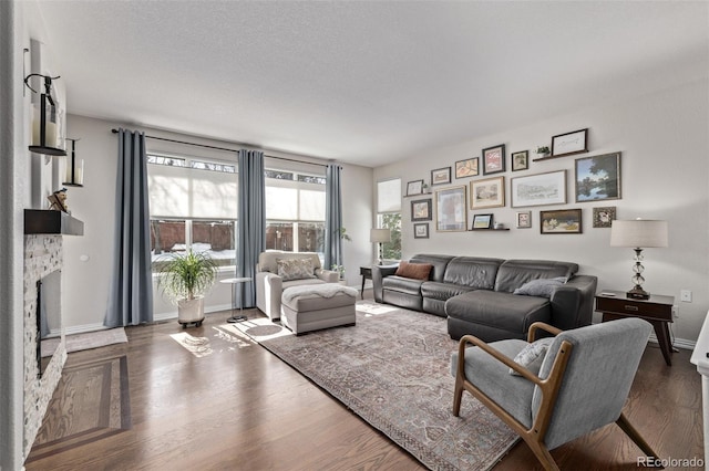 living area with dark wood-style floors, a fireplace, and baseboards