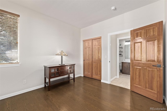 interior space with a closet, wood finished floors, and baseboards