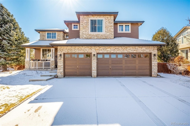 prairie-style home featuring stone siding, covered porch, and concrete driveway