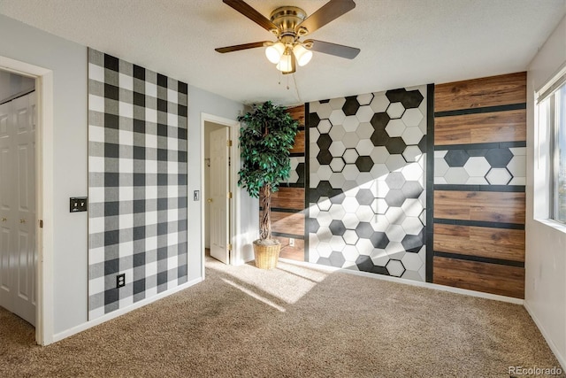 unfurnished bedroom featuring a ceiling fan, carpet flooring, and a textured ceiling