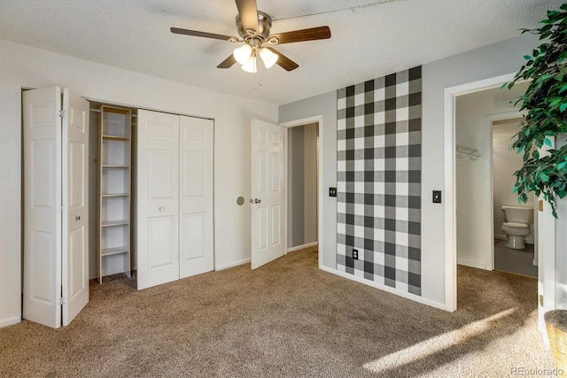 unfurnished bedroom with baseboards, a closet, ceiling fan, and carpet