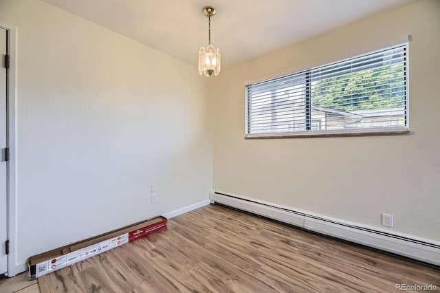 5995 W Hampden Ave Unit 2G, Denver, CO 80227 - empty room with baseboard heating, light wood-type flooring, a chandelier, and baseboards