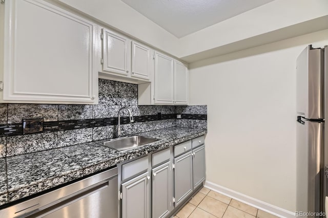5995 W Hampden Ave Unit 2G, Denver, CO 80227 - kitchen with stainless steel appliances, a sink, tasteful backsplash, light tile patterned floors, and baseboards