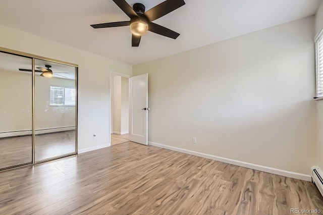 5995 W Hampden Ave Unit 2G, Denver, CO 80227 - unfurnished bedroom with a baseboard radiator, light wood-style flooring, and baseboards