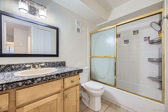 5995 W Hampden Ave Unit 2G, Denver, CO 80227 - full bathroom with vanity, toilet, tile patterned floors, shower / bath combination with glass door, and a textured wall
