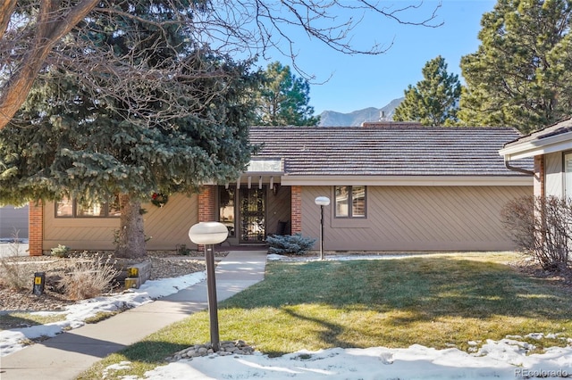 view of front of house with a mountain view and a front lawn