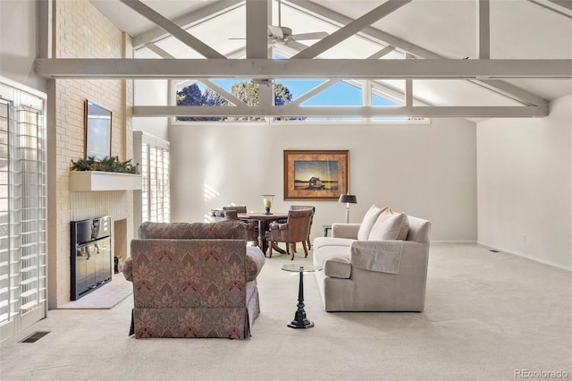 carpeted living room with a brick fireplace, beamed ceiling, high vaulted ceiling, and ceiling fan