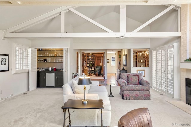 living room with high vaulted ceiling, a fireplace, indoor bar, carpet floors, and plenty of natural light