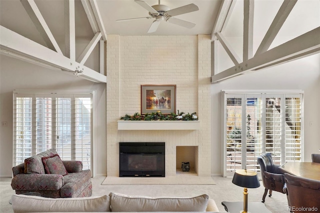 carpeted living room with beam ceiling, ceiling fan, high vaulted ceiling, and a fireplace