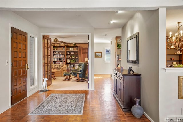 foyer featuring parquet floors and a chandelier