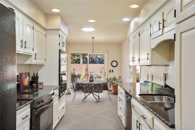 kitchen with white cabinets, dark stone counters, hanging light fixtures, light colored carpet, and black appliances