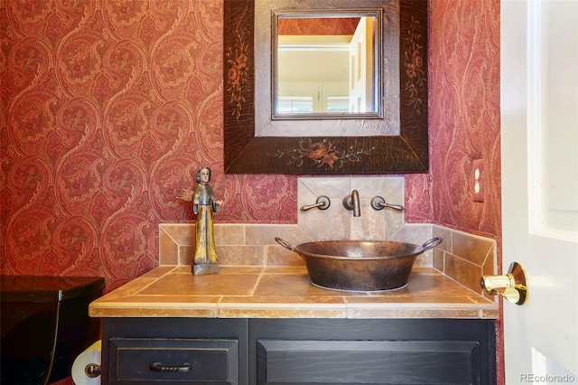 bathroom featuring vanity and decorative backsplash