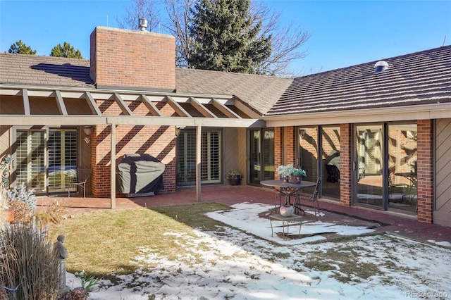 snow covered property featuring a patio