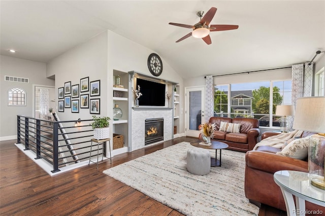 living area featuring wood finished floors, built in features, baseboards, ceiling fan, and lofted ceiling