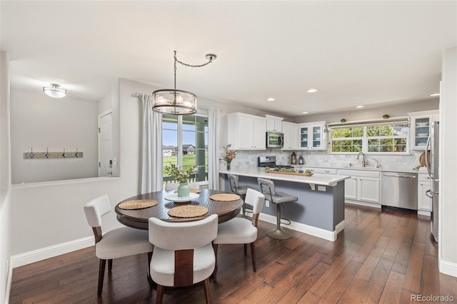 dining area featuring dark wood-type flooring, recessed lighting, baseboards, and a chandelier
