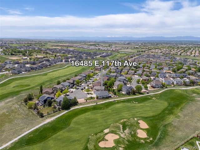 aerial view of property's location with nearby suburban area, a local golf course, and a mountainous background