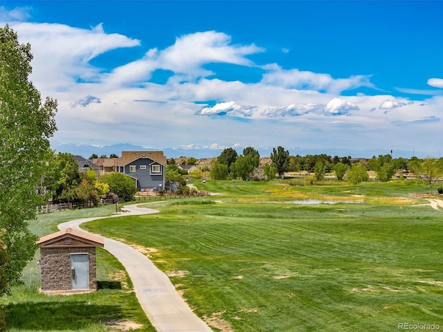 view of property's community with a water view and a lawn