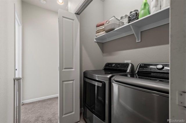 clothes washing area featuring light colored carpet and separate washer and dryer