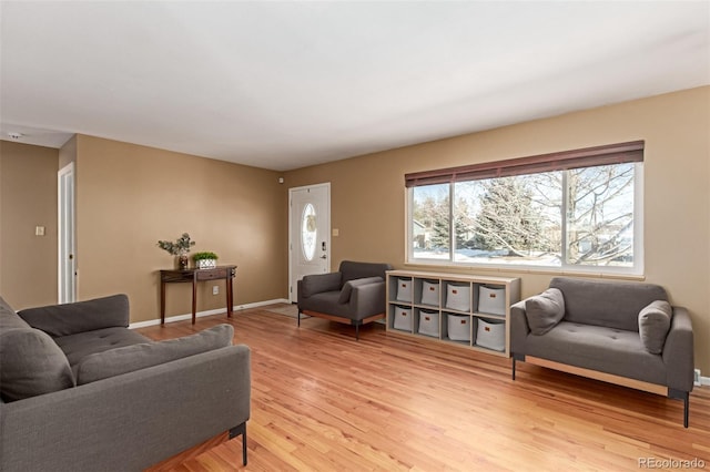 living area featuring light wood-style flooring and baseboards