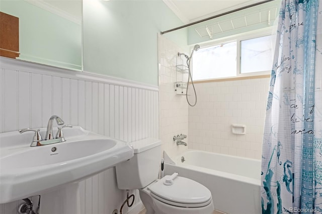 full bathroom with toilet, a wainscoted wall, a sink, ornamental molding, and shower / bath combo with shower curtain