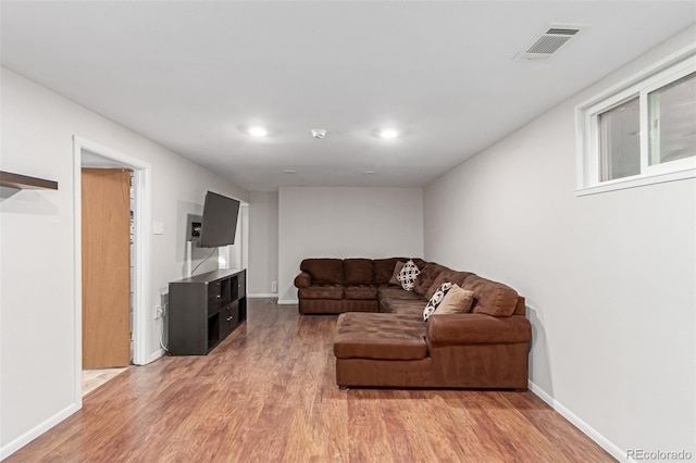 living room featuring recessed lighting, baseboards, visible vents, and light wood finished floors