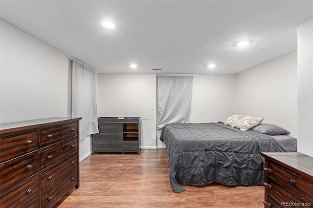 bedroom with baseboards, light wood-type flooring, and recessed lighting