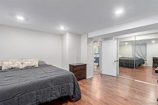 bedroom featuring baseboards, wood finished floors, and recessed lighting