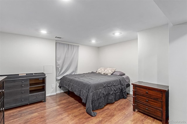 bedroom with baseboards, visible vents, wood finished floors, and recessed lighting