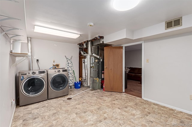 washroom with visible vents, separate washer and dryer, laundry area, baseboards, and tile patterned floors