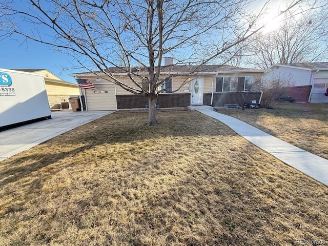 ranch-style house with a front yard and brick siding