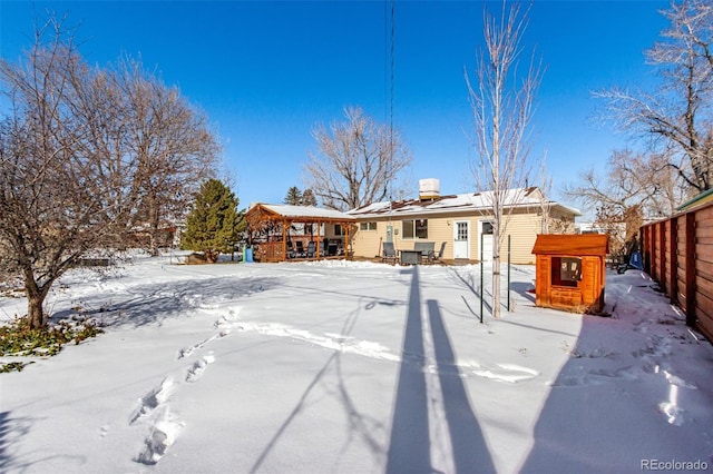 snow covered property with fence