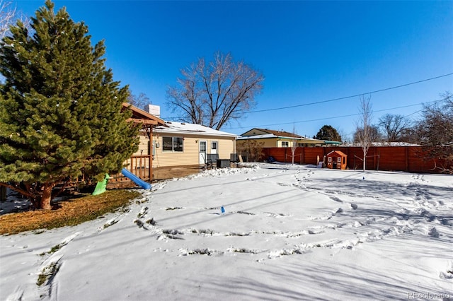 yard covered in snow featuring fence