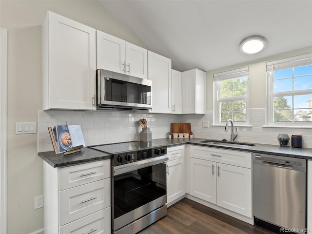 16986 E Piedmont Dr Unit A, Aurora, CO 80015 - kitchen featuring appliances with stainless steel finishes, white cabinetry, tasteful backsplash, dark wood-style floors, and lofted ceiling