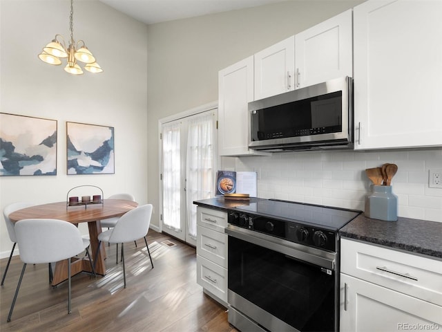 16986 E Piedmont Dr Unit A, Aurora, CO 80015 - kitchen with stainless steel microwave, range with electric cooktop, dark countertops, and a chandelier