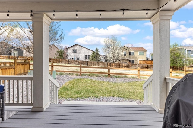 wooden deck with a lawn, a fenced backyard, and a residential view