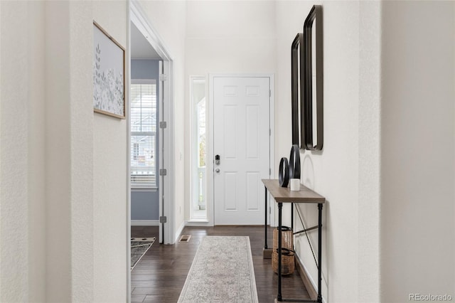entryway featuring baseboards, visible vents, and dark wood-style floors