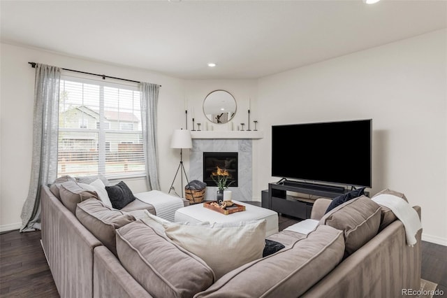living area featuring recessed lighting, baseboards, a fireplace, and dark wood-style flooring