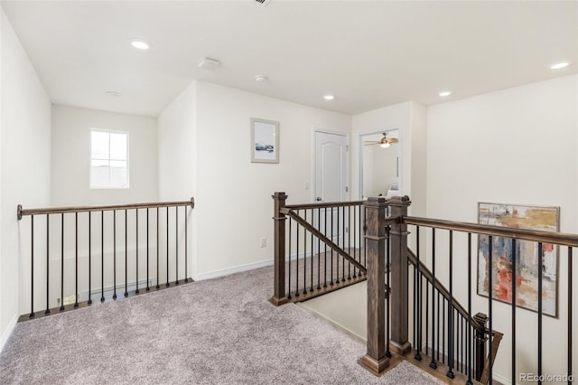 corridor with recessed lighting, carpet flooring, and an upstairs landing