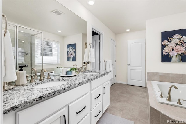 full bath featuring double vanity, visible vents, a sink, and a bath