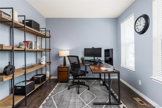 office area featuring baseboards, visible vents, a healthy amount of sunlight, and wood finished floors