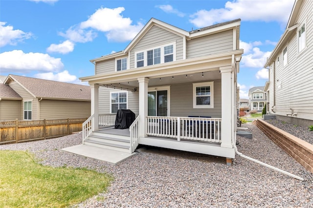 back of property featuring fence and a porch
