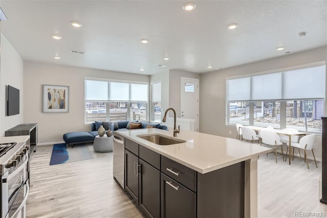 9457 W 58th Ln Unit A, Arvada, CO 80002 - kitchen featuring open floor plan, light wood-style floors, stainless steel appliances, light countertops, and recessed lighting