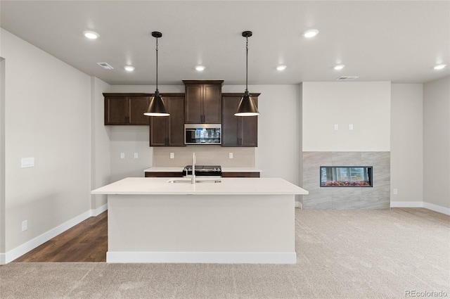 9457 W 58th Ln Unit A, Arvada, CO 80002 - kitchen featuring stainless steel microwave, dark brown cabinets, light countertops, dark carpet, and recessed lighting