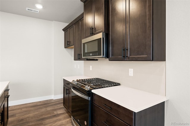 9457 W 58th Ln Unit A, Arvada, CO 80002 - kitchen featuring appliances with stainless steel finishes, dark brown cabinetry, tasteful backsplash, dark wood-style flooring, and light countertops