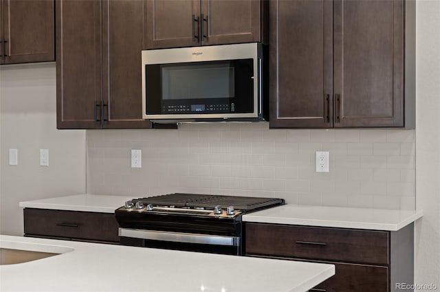 9457 W 58th Ln Unit A, Arvada, CO 80002 - kitchen featuring stainless steel microwave, gas stove, dark brown cabinets, and decorative backsplash