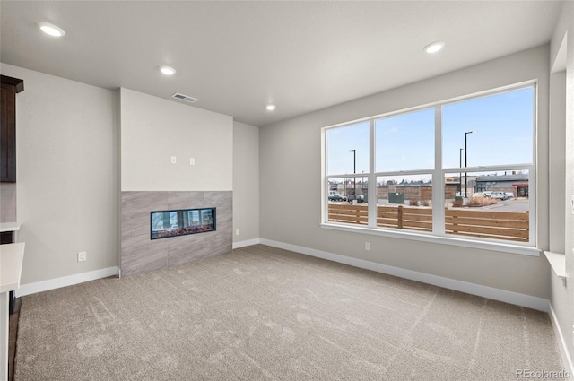 9457 W 58th Ln Unit A, Arvada, CO 80002 - unfurnished living room with a tiled fireplace, carpet, and recessed lighting