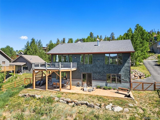 222 Idlewild Dr, Dillon, CO 80435 - back of property with a wooden deck, a patio area, a fenced backyard, and a shingled roof