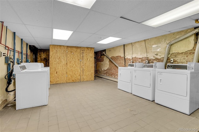 laundry area with brick wall and separate washer and dryer