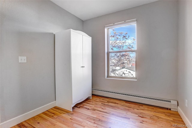 unfurnished bedroom featuring light hardwood / wood-style flooring and a baseboard radiator