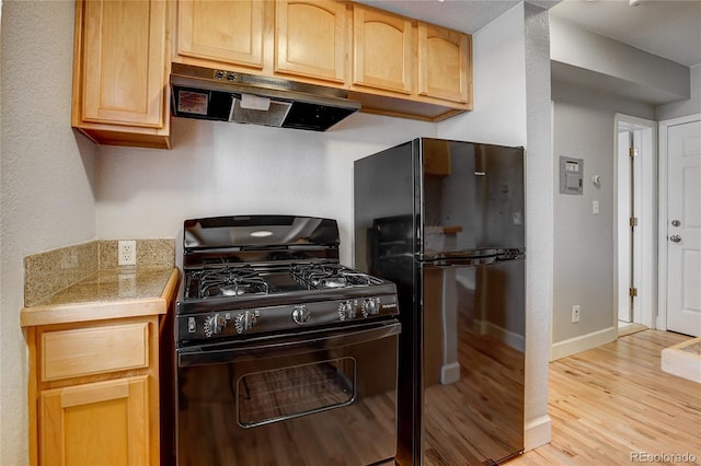 kitchen with light hardwood / wood-style flooring, black appliances, and light brown cabinets